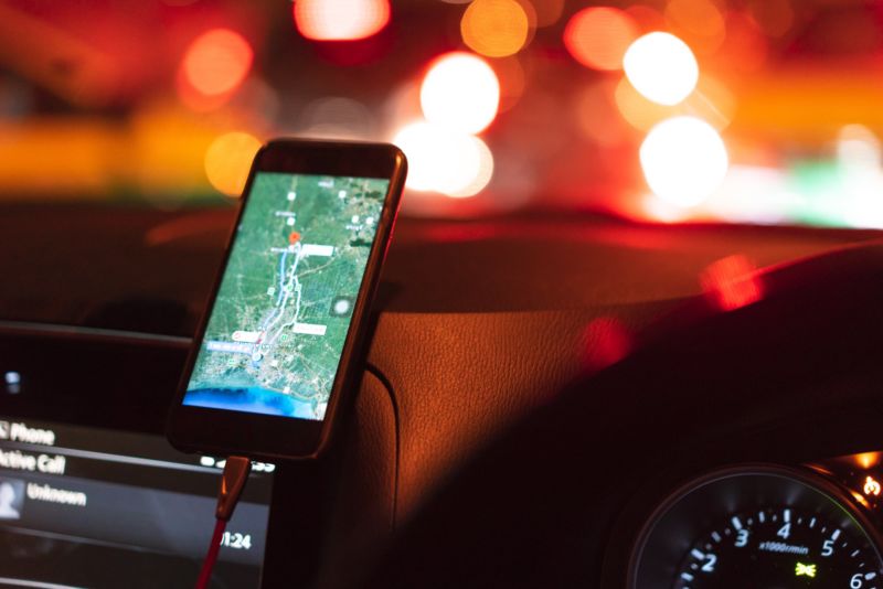 A smartphone mounted on a car dashboard and displaying a GPS map.