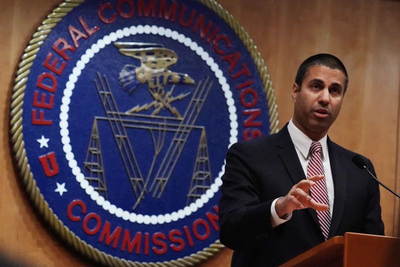 FCC Chairman Ajit Pai talking while standing in front of an FCC seal.