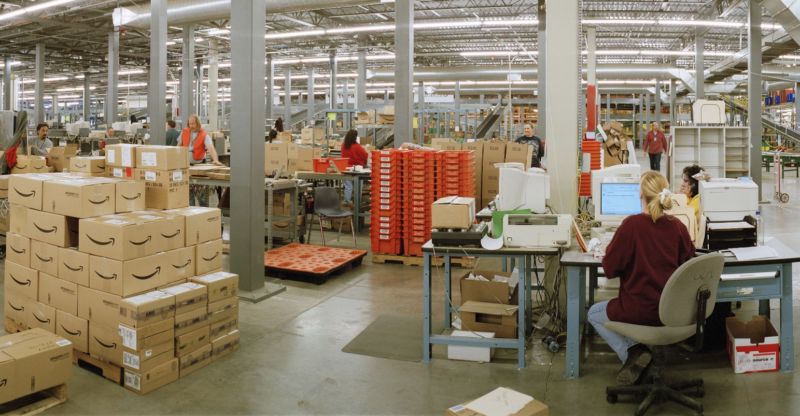 Workers and packages inside an Amazon warehouse.