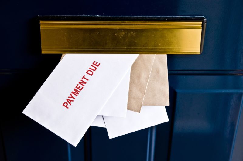 Envelopes sticking out of the mail slot in a door with the text on the top envelope saying, 