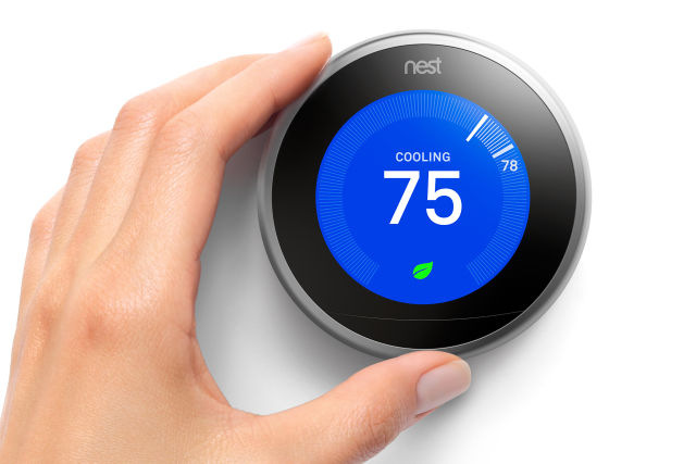Promotional image of a hand adjusting a digital thermostat.
