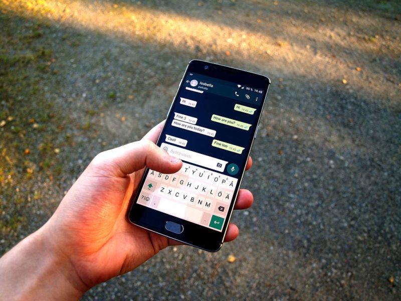 Photograph of a hand using WhatsApp on a smartphone.